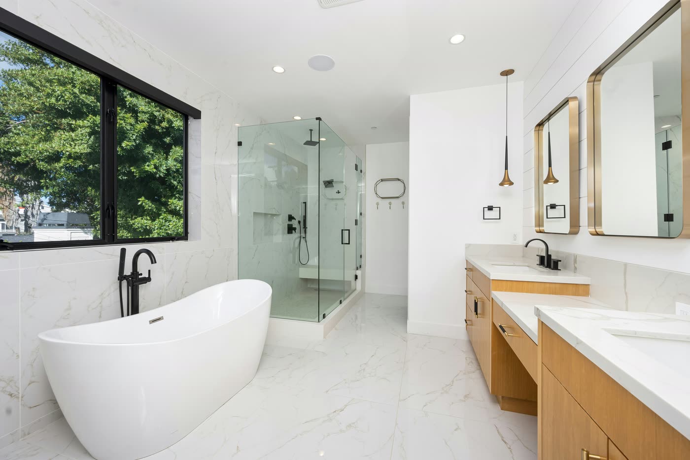 Bathroom renovation with a freestanding bath, frameless glass shower, timber double vanity and marble-look floor-to-ceiling tiling