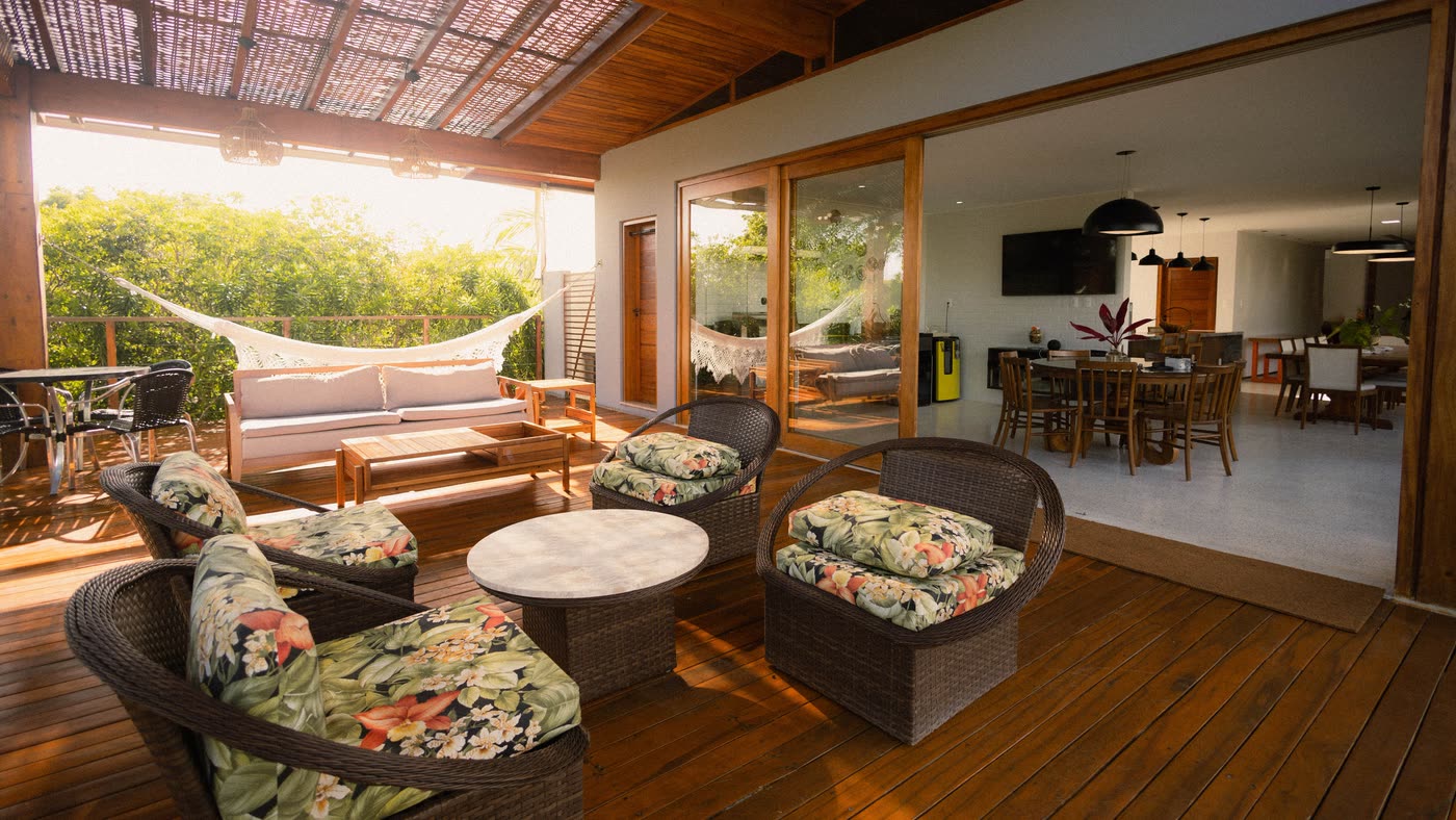 Alfresco extension with a timber-lined ceiling and lounge seating, opening through sliding doors into an open-plan living and dining space